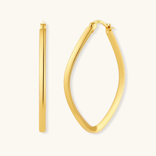 Set of geometric gold-plated sterling silver hoop earrings in oval and cushion shapes on cream background